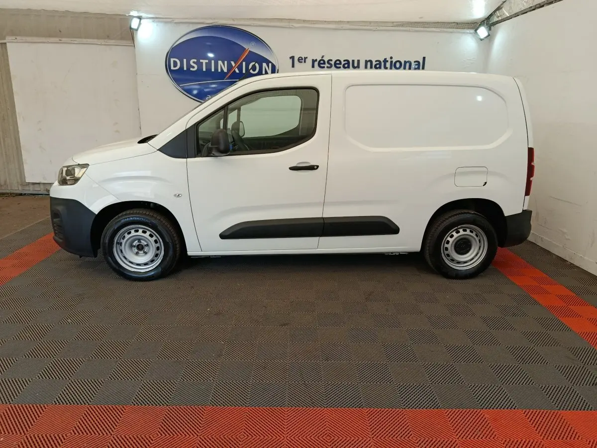 Vue de profil côté gauche d'un utilitaire Citroën Berlingo blanc, avec jantes acier et protections latérales noires.