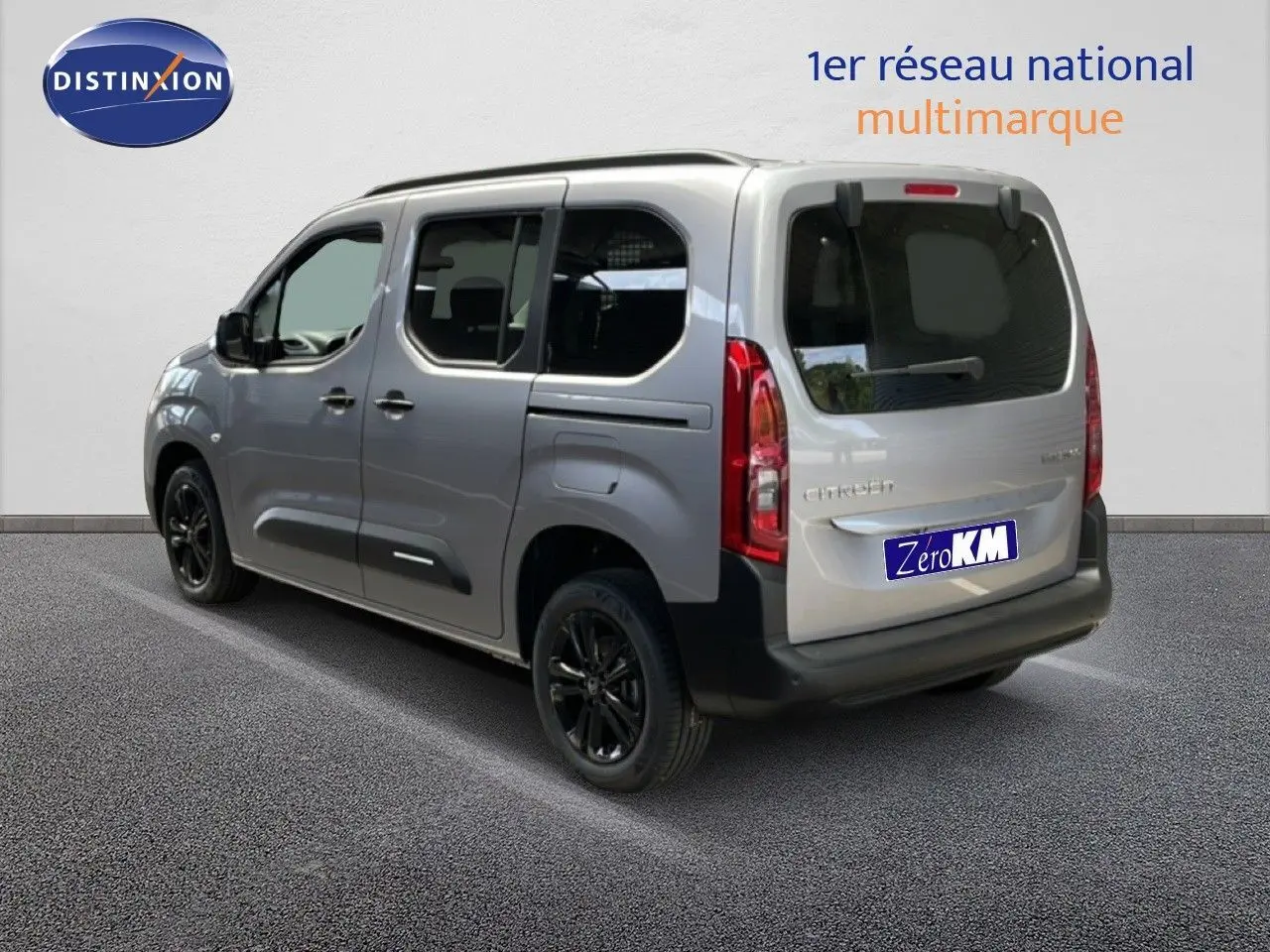 Vue 3/4 arrière droite d'un Citroën Berlingo gris Artense métallisé avec jantes noires et vitres teintées.