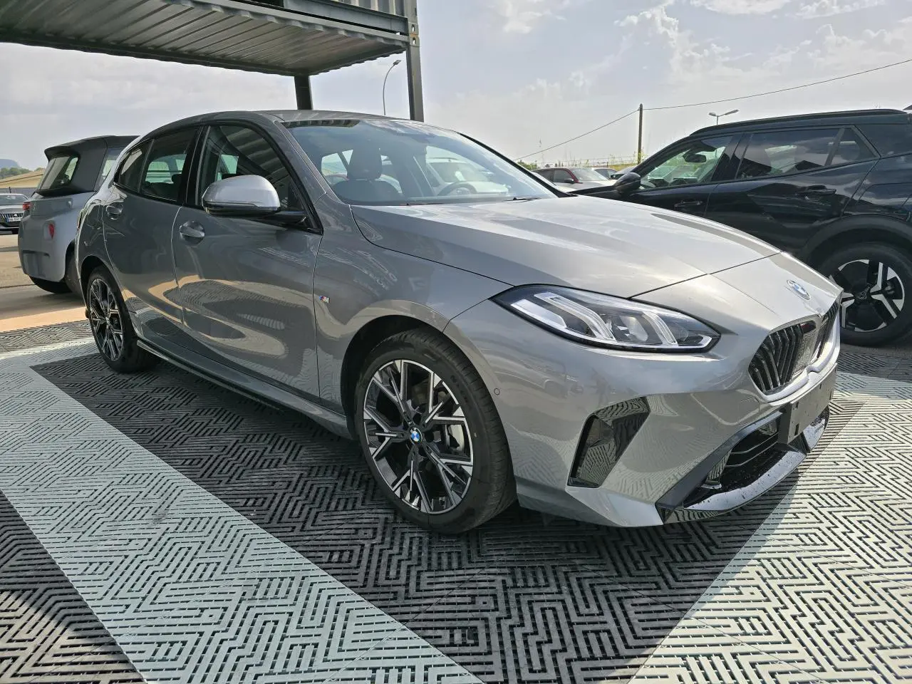 BMW Série 1 120D M Sport gris Skyscraper vue 3/4 avant droit avec jantes 18 pouces bicolores et calandre chromée