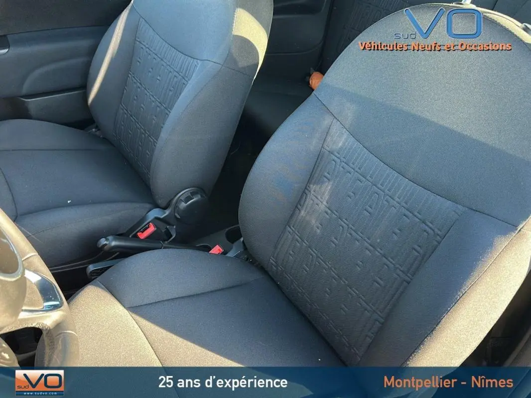 Gros plan sur les sièges avant noirs du Fiat 500C 2024, avec motif texturé et volant partiellement visible côté gauche.