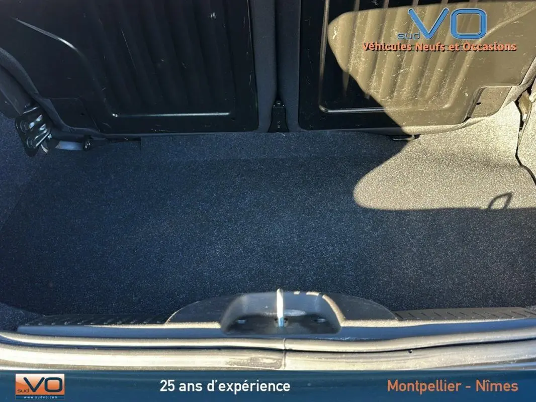 Coffre ouvert d'une FIAT 500C noire 2024, vue plongeante montrant l'espace de rangement et la roue de secours.