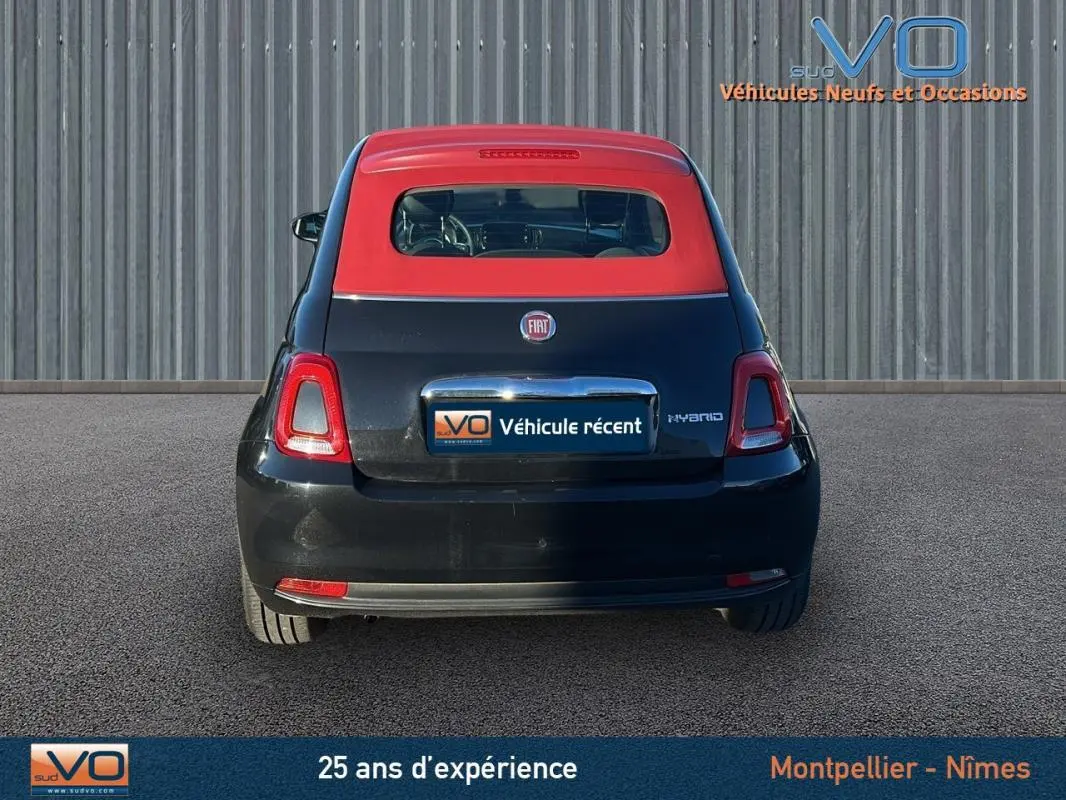 Vue arrière d'une FIAT 500C noire avec toit rouge, version hybride 2024, affichant le logo et l'inscription Hybrid.