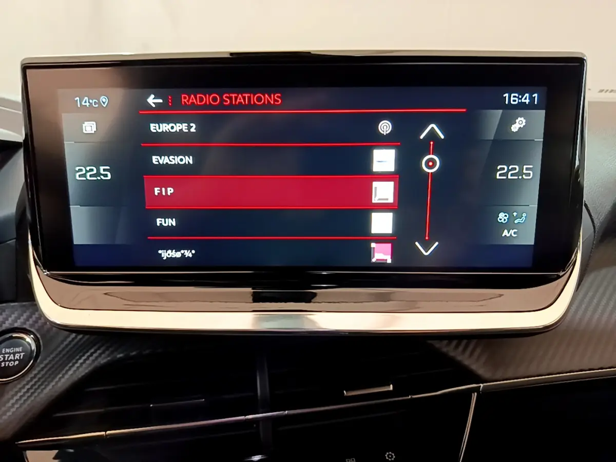 Écran tactile central 10 pouces du tableau de bord du Peugeot 2008 noir, affichant les stations radio et la température.