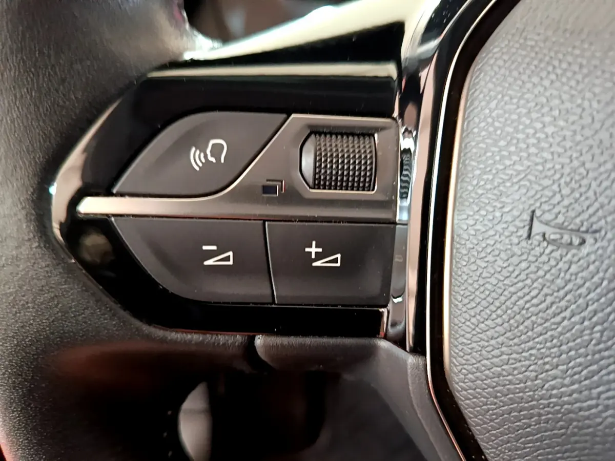 Gros plan sur les commandes gauche du volant cuir noir du Peugeot 2008 PureTech 130 S&S Allure Business 2021.