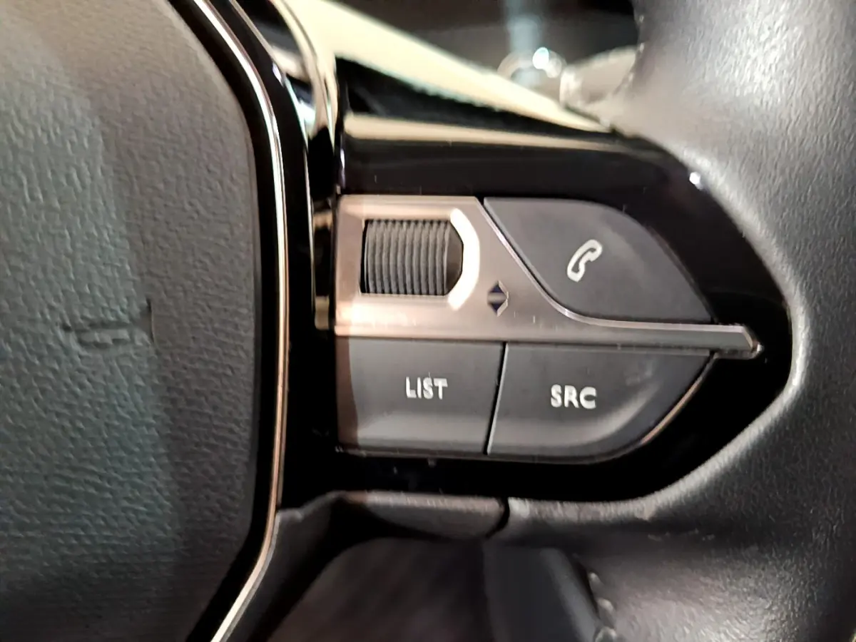 Gros plan sur les commandes du volant côté gauche du Peugeot 2008 noir PureTech 130 S&S Allure Business 2021.