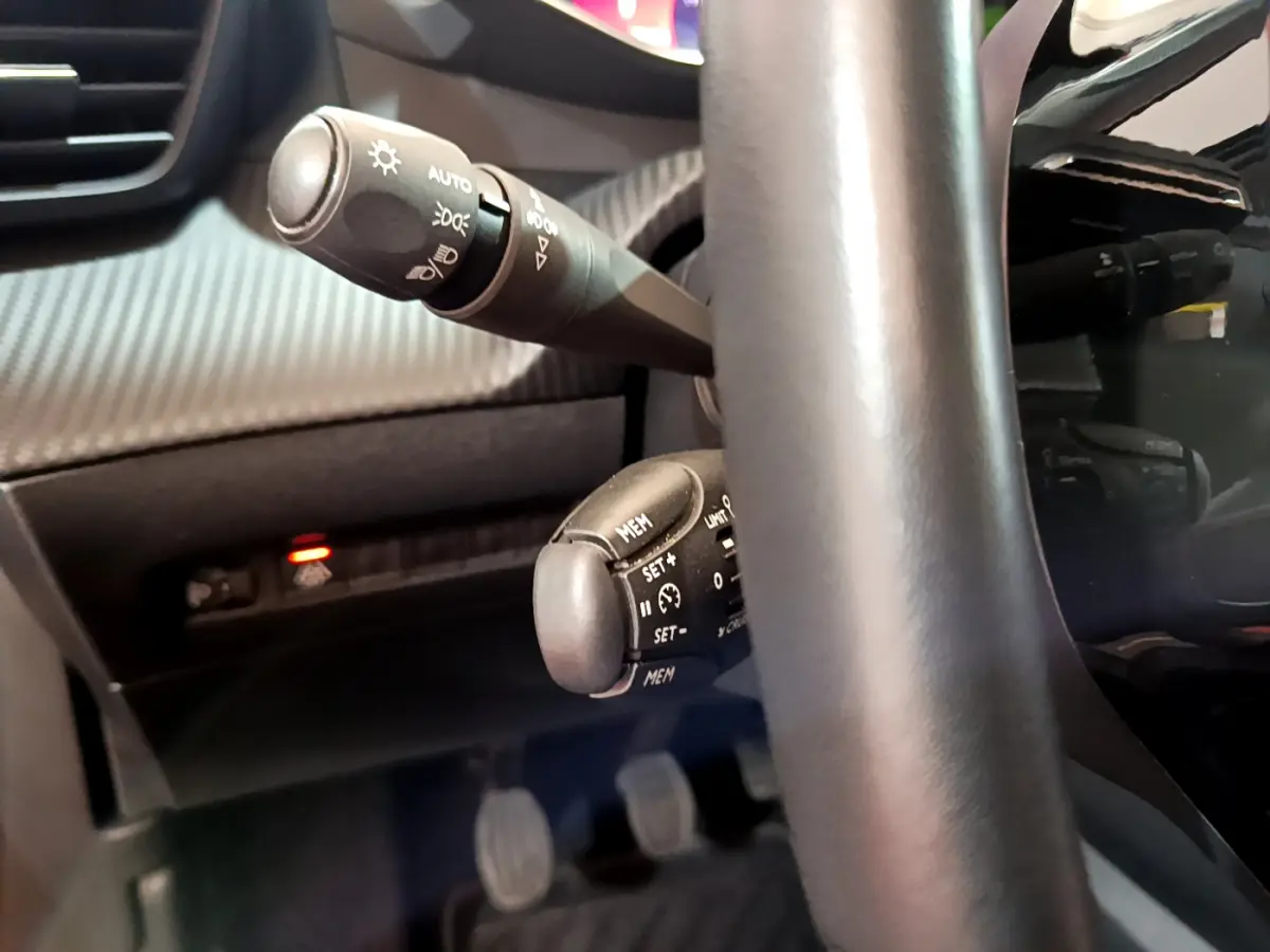 Gros plan sur les commandes au volant cuir noir du Peugeot 2008 PureTech 130 S&S Allure Business 2021.