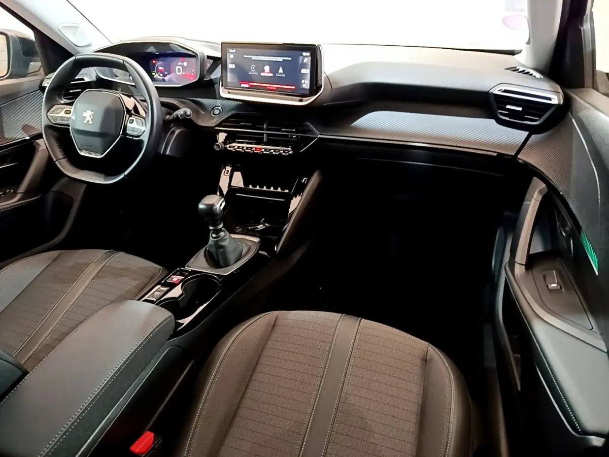 Intérieur noir du Peugeot 2008 PureTech 130, vue côté passager avec tableau de bord et écran tactile central.