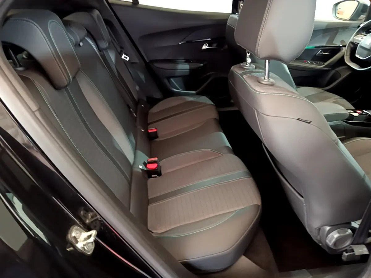 Vue intérieure côté gauche montrant la banquette arrière en tissu et cuir gris du Peugeot 2008 noir 2021 PureTech Allure Business