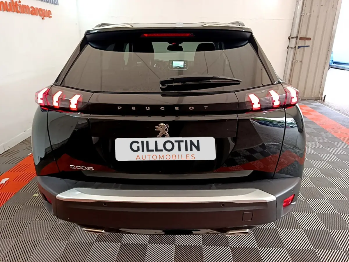 Vue arrière d'un Peugeot 2008 noir avec feux LED caractéristiques et logo lion visible sur le hayon.