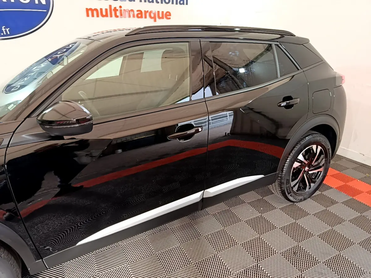 Profil côté gauche du Peugeot 2008 noir 2021 avec jantes alliage et rétroviseurs noirs brillants.