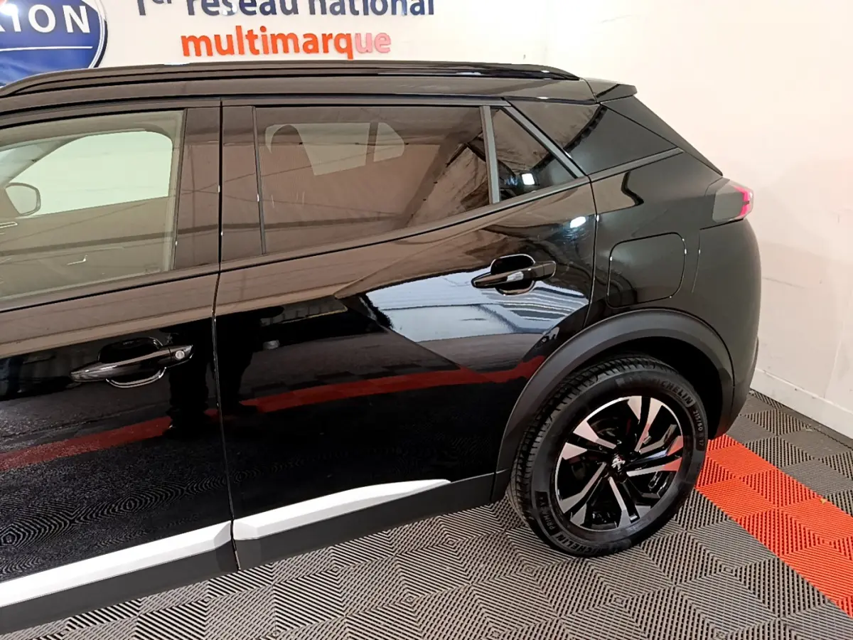 Profil côté droit du Peugeot 2008 noir 2021, mettant en valeur les jantes alliage et les lignes modernes du SUV.