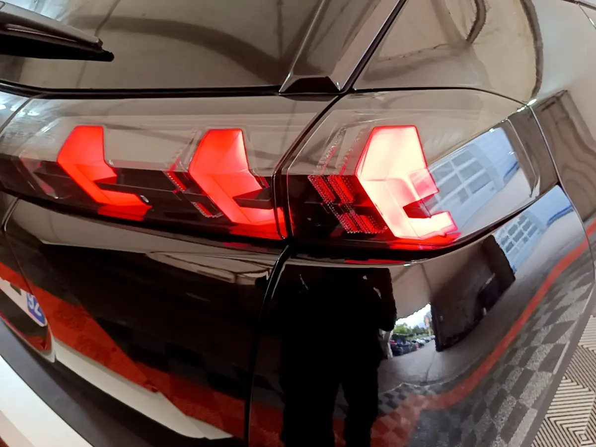 Gros plan sur les feux arrière rouges en forme de griffes du Peugeot 2008 noir, vue côté droit arrière.