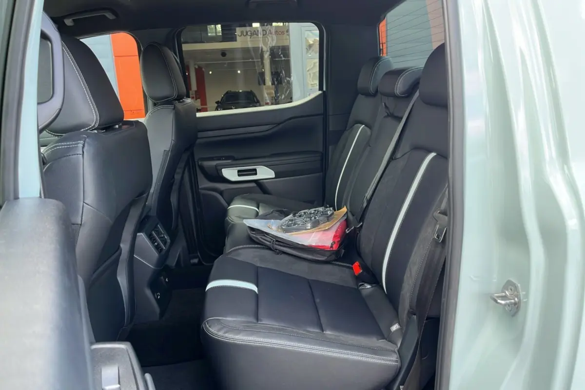 Vue intérieure côté droit du Ford Ranger 2.3 PHEV gris zen, montrant la banquette arrière en cuir noir avec surpiqûres blanches.