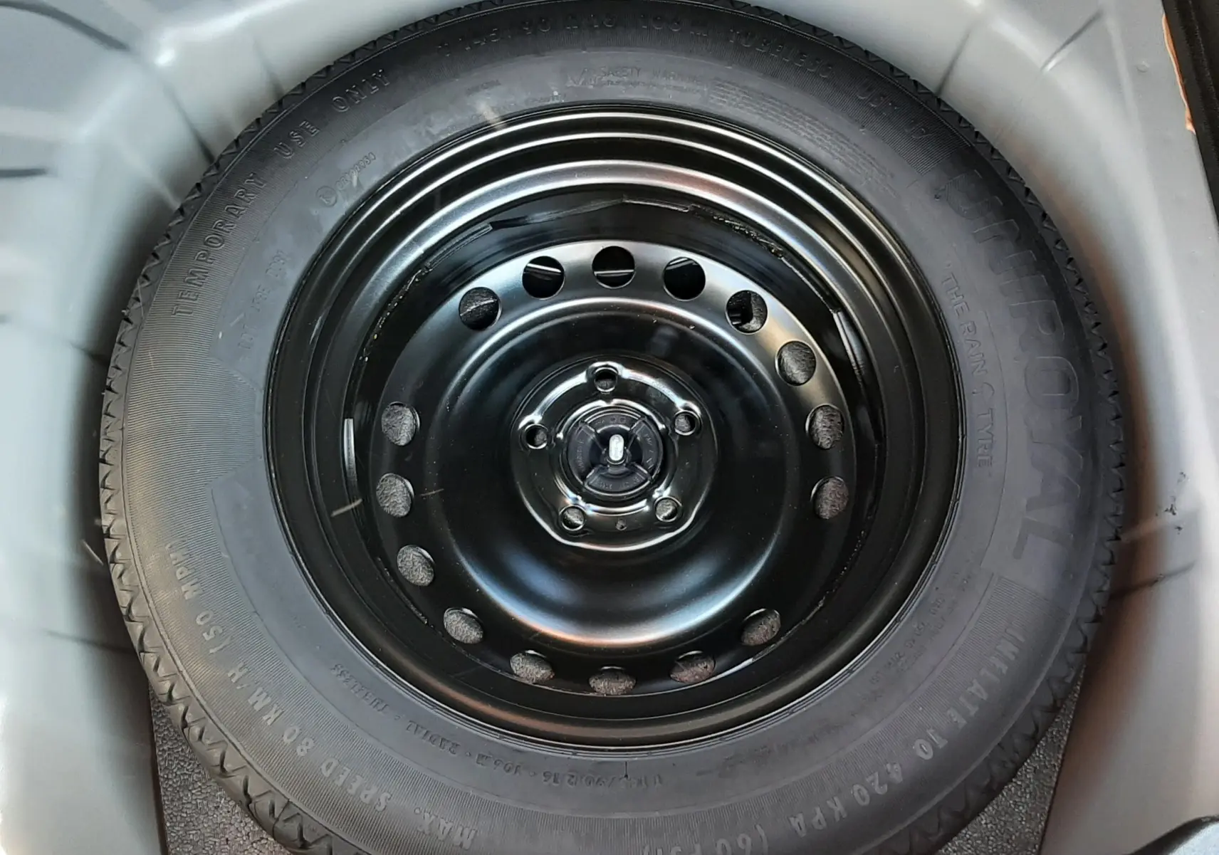 Gros plan sur la roue de secours noire dans le coffre du Renault Captur II gris Cassiopée 2025.