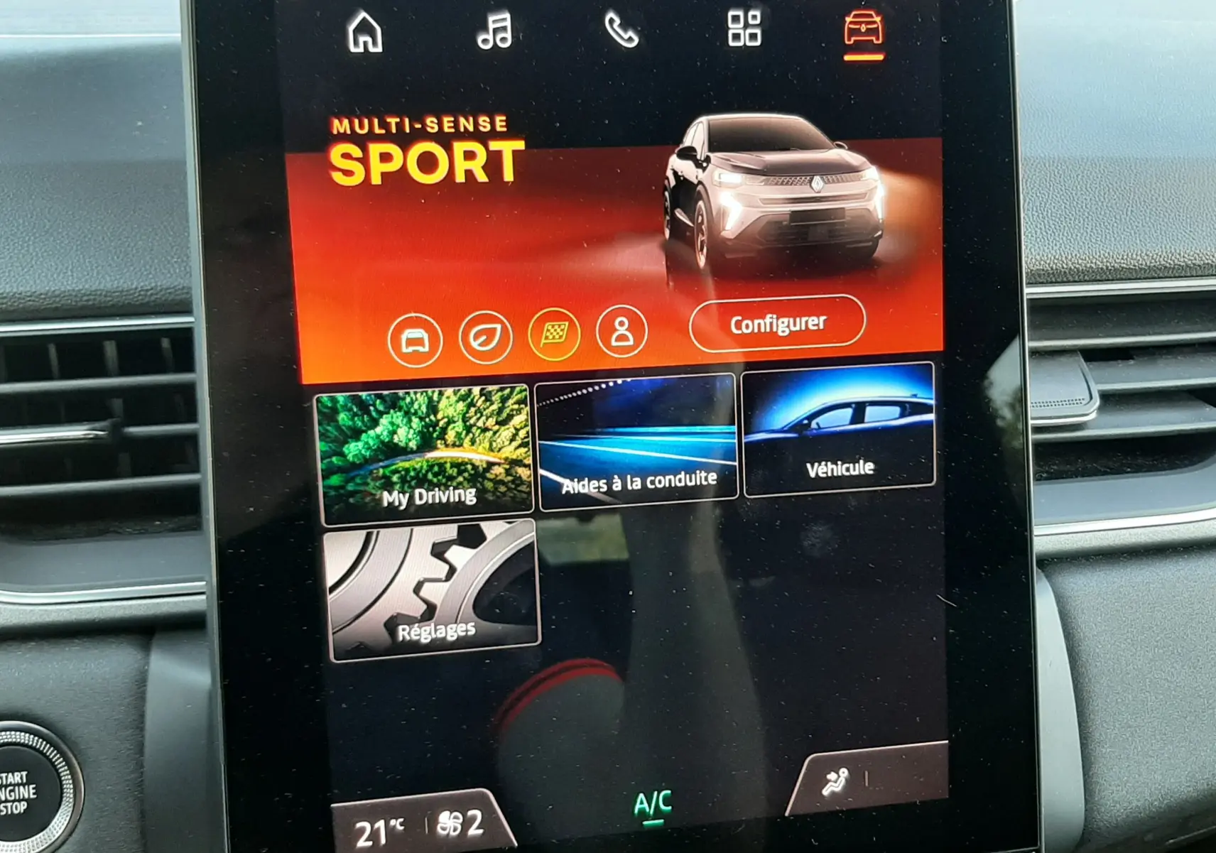 Écran tactile central du Renault Captur II affichant le mode de conduite Sport avec interface moderne et commandes climatisation visibles.