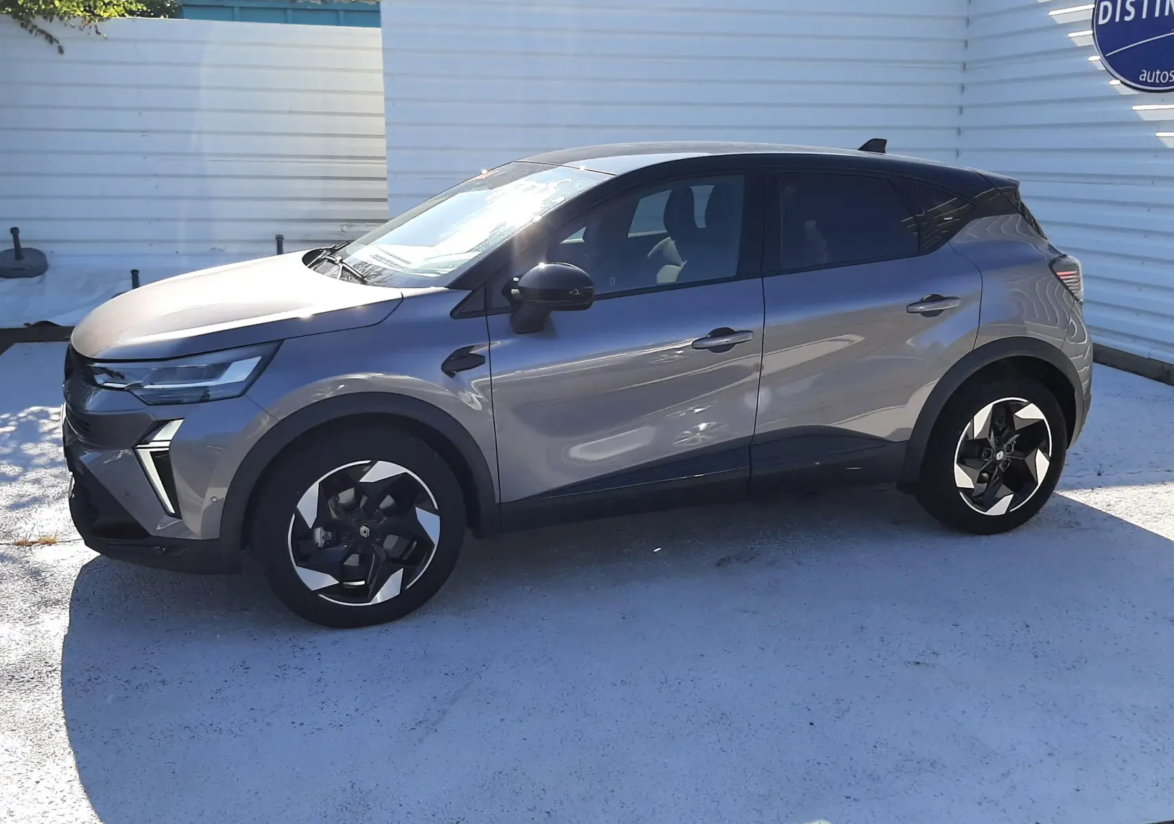 Renault Captur II gris Cassiopée vu de profil côté gauche, avec jantes noires et toit noir contrasté.
