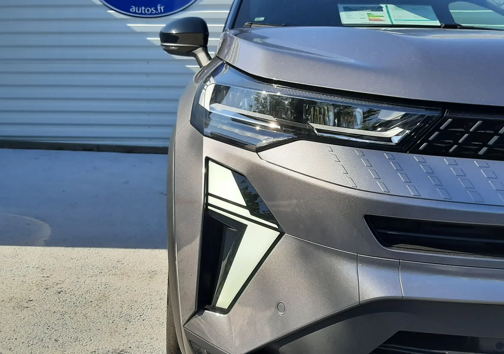 Vue avant droite du Renault Captur II gris Cassiopée 2025, mettant en valeur ses phares LED et la calandre moderne.