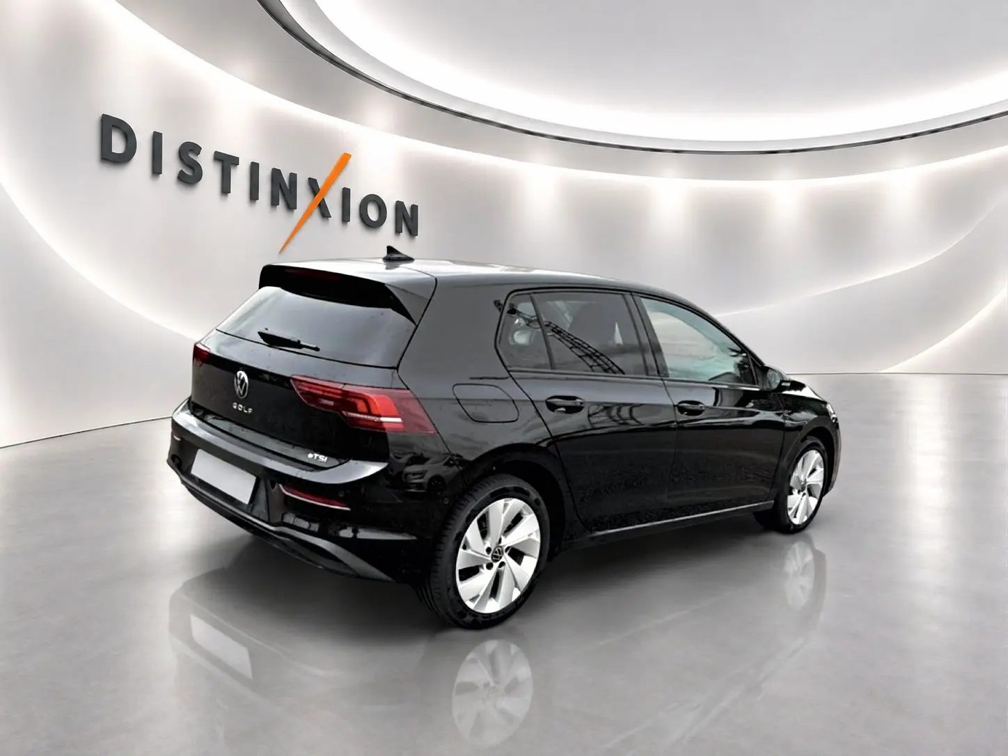 Volkswagen Golf noir vue 3/4 arrière droit en intérieur avec jantes alu 17 pouces et feux arrière LED.