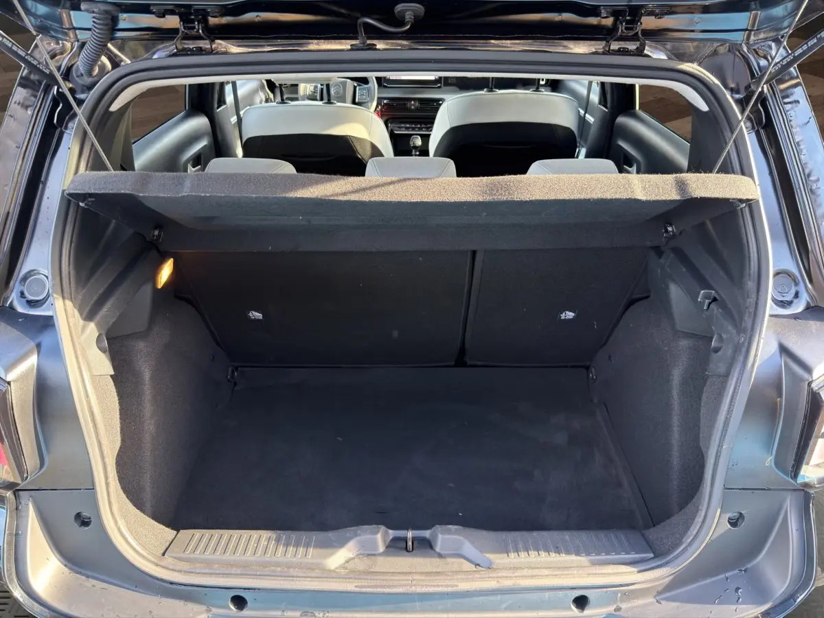 Vue arrière du coffre ouvert d'une Citroën C3 noire 2025, montrant l'espace de chargement et l'intérieur des sièges arrière.