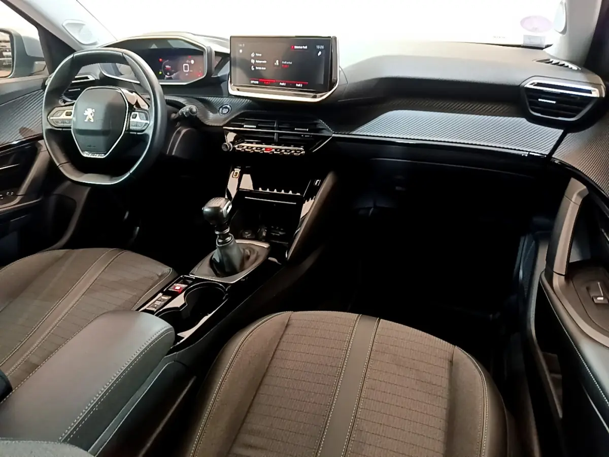 Intérieur noir de la Peugeot 2008 PureTech 130, vue depuis le siège passager avec tableau de bord et écran tactile central.