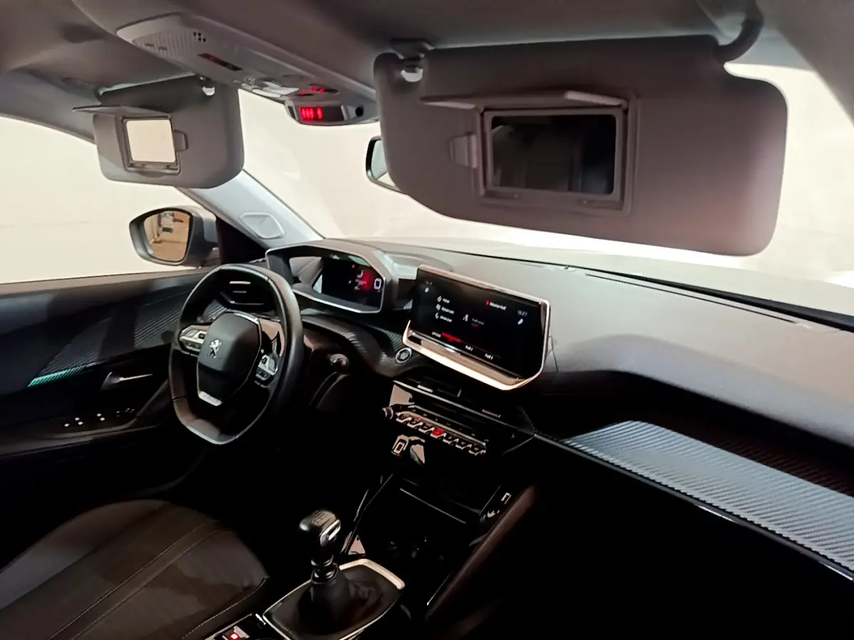 Intérieur avant du Peugeot 2008 gris clair, tableau de bord avec écran tactile et volant multifonctions cuir.