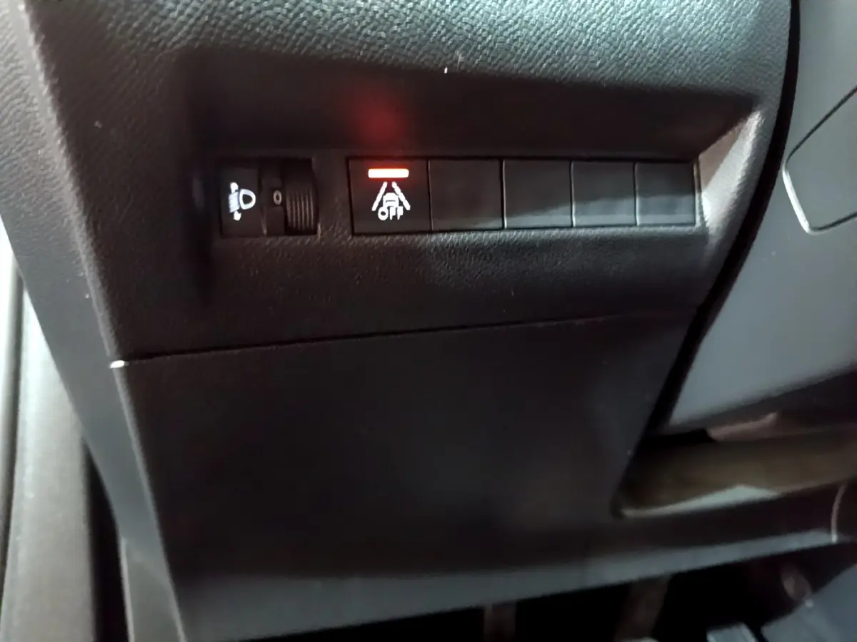 Gros plan sur les commandes de réglage des phares et d'alerte de franchissement de ligne dans le tableau de bord d'une Peugeot 2008.