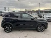 Vue de profil côté gauche d'une Citroën C3 1.2 turbo noire 2025, essence, boîte manuelle, sur parking extérieur.