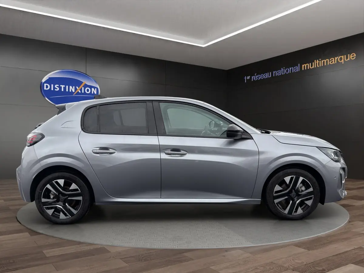Peugeot 208 gris clair vue de profil côté gauche, avec jantes noires et détails modernes visibles.