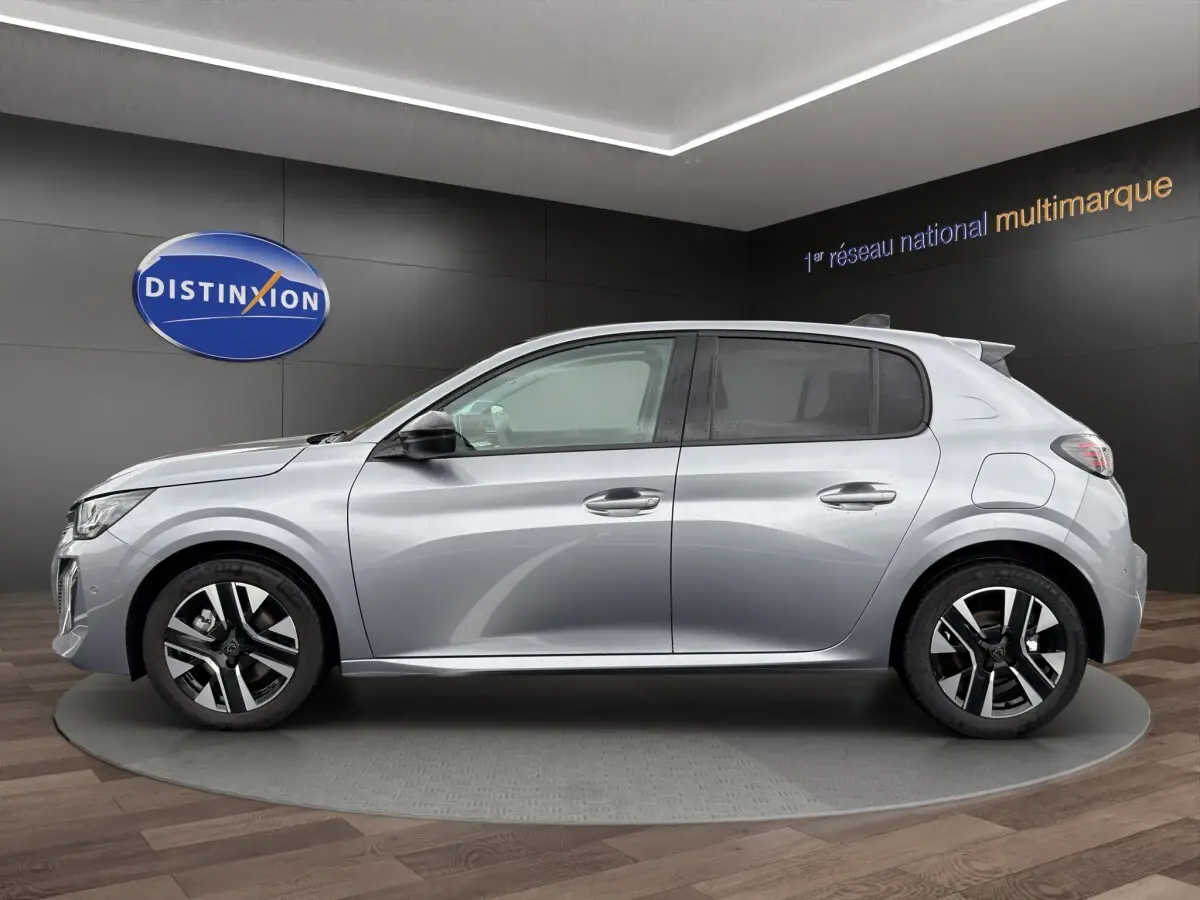 Peugeot 208 gris clair vue de profil côté gauche, avec jantes alliage et rétroviseurs noirs.