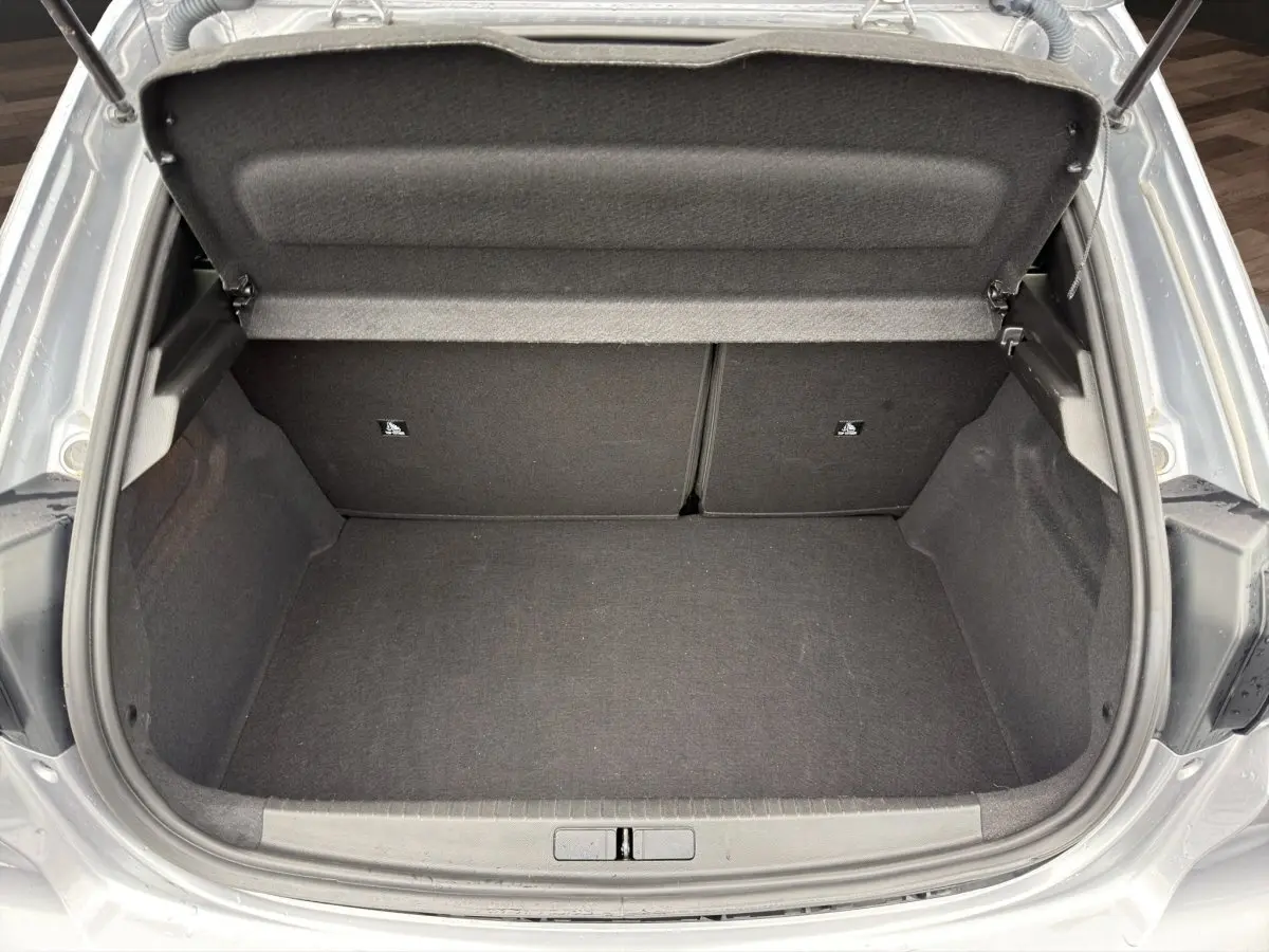 Vue plongeante sur le coffre ouvert gris clair de la Peugeot 208 2025, montrant un espace de rangement propre et spacieux.