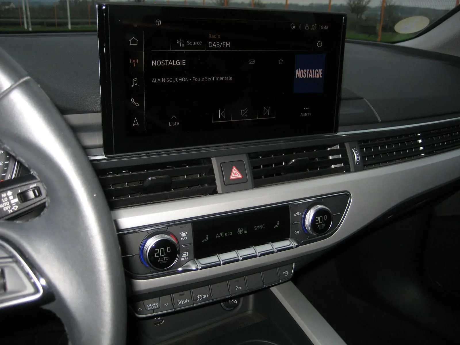 Vue intérieure du tableau de bord de l'Audi A4 Avant noir 2022, avec écran tactile et commandes climatisation digitales.