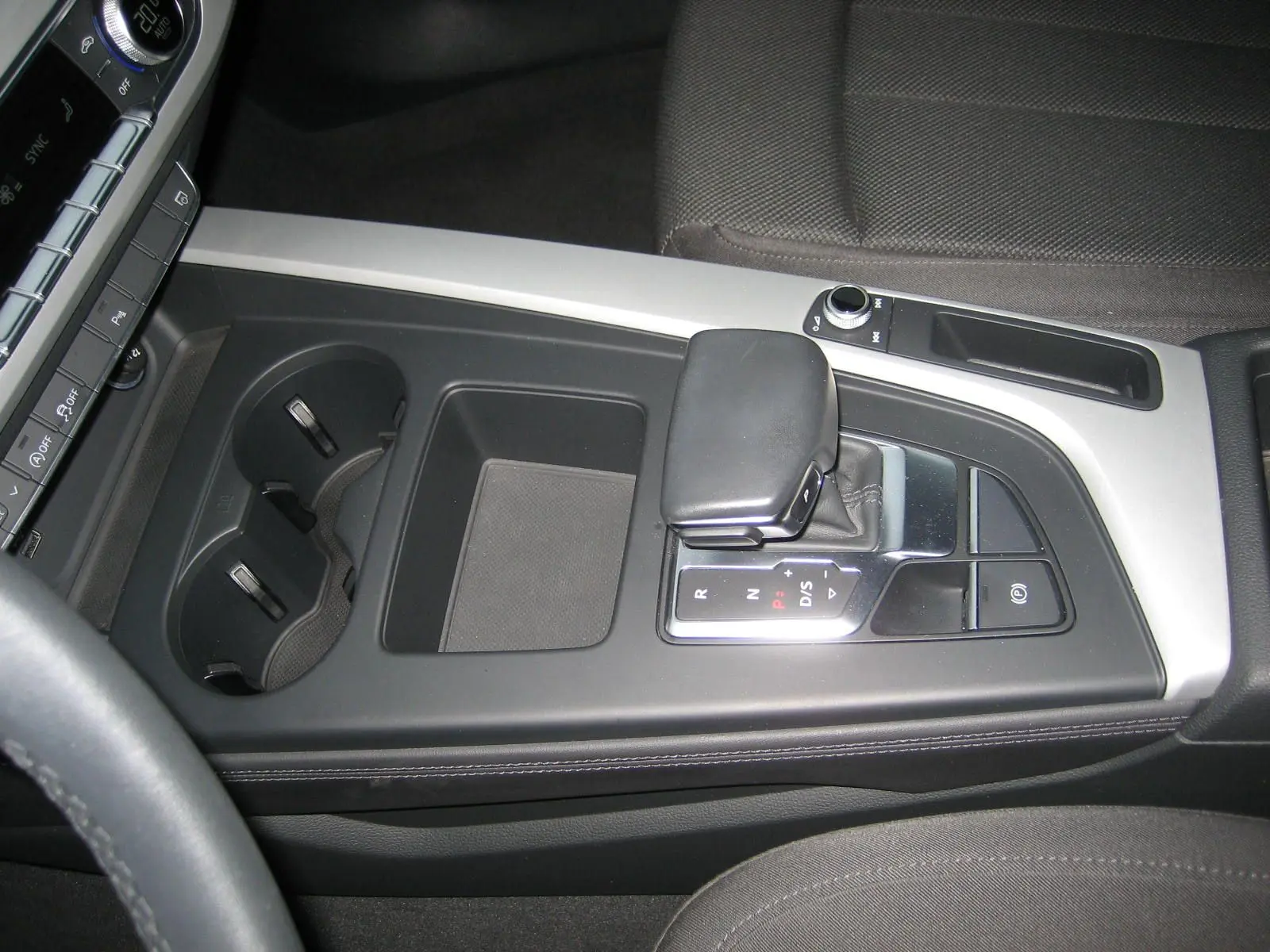 Vue rapprochée de la console centrale noire de l'Audi A4 Avant 3.5 TDI 2022 avec levier de boîte automatique et porte-gobelets.