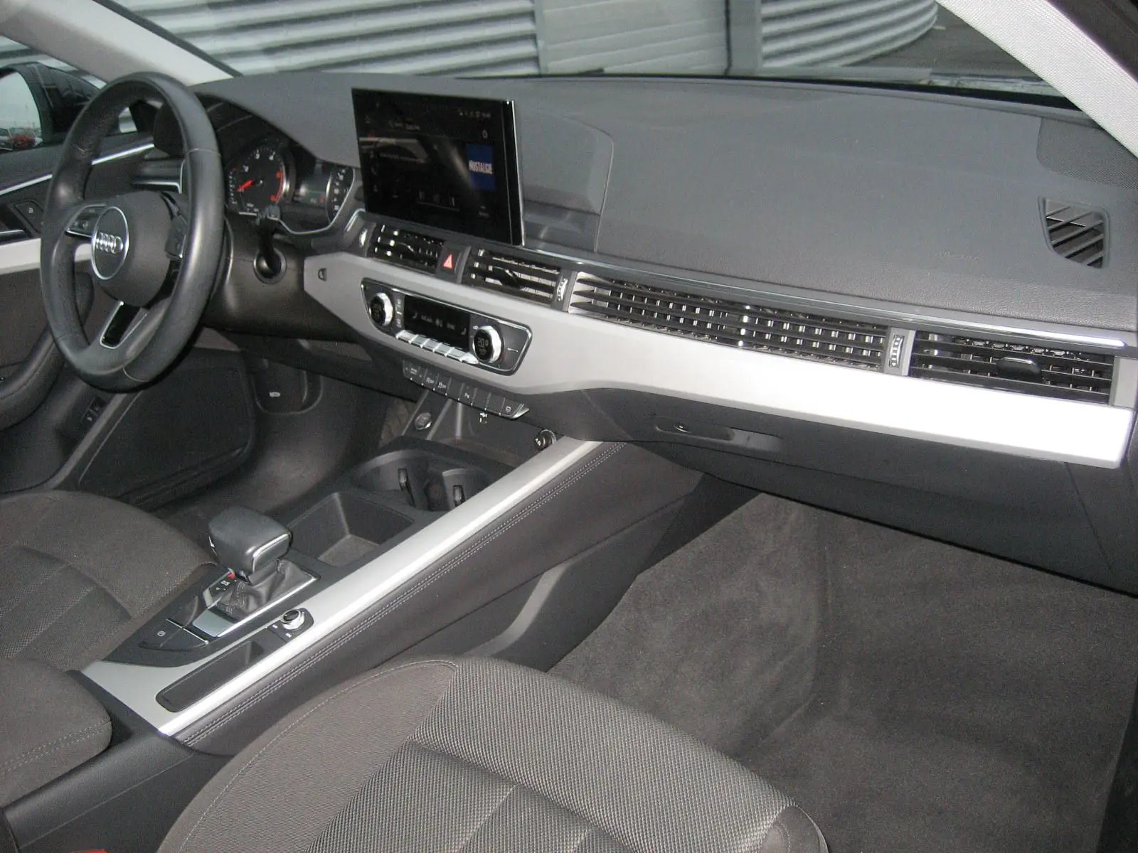 Intérieur de l'Audi A4 Avant 3.5 TDI 2022, vue côté conducteur sur tableau de bord et console centrale noire et argentée.