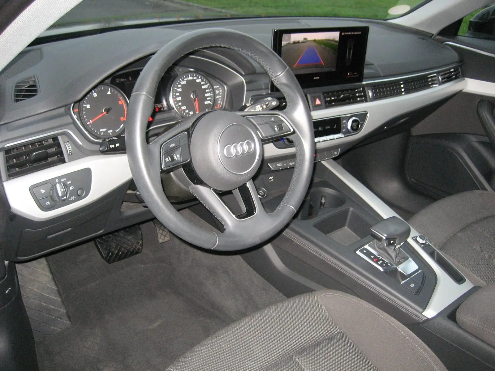 Intérieur Audi A4 Avant 2022 vu côté conducteur, tableau de bord noir avec écran central et levier de boîte automatique.