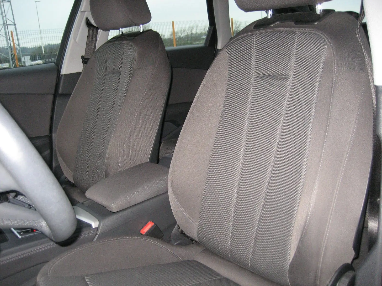 Intérieur de l'Audi A4 Avant 3.5 TDI 163 S Tronic Design 2022, vue rapprochée sur les sièges avant en tissu gris.