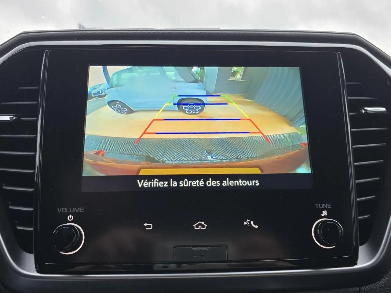 Écran tactile 7" affichant la caméra de recul du pick-up Isuzu D-MAX orange métal, vue arrière avec lignes de guidage.