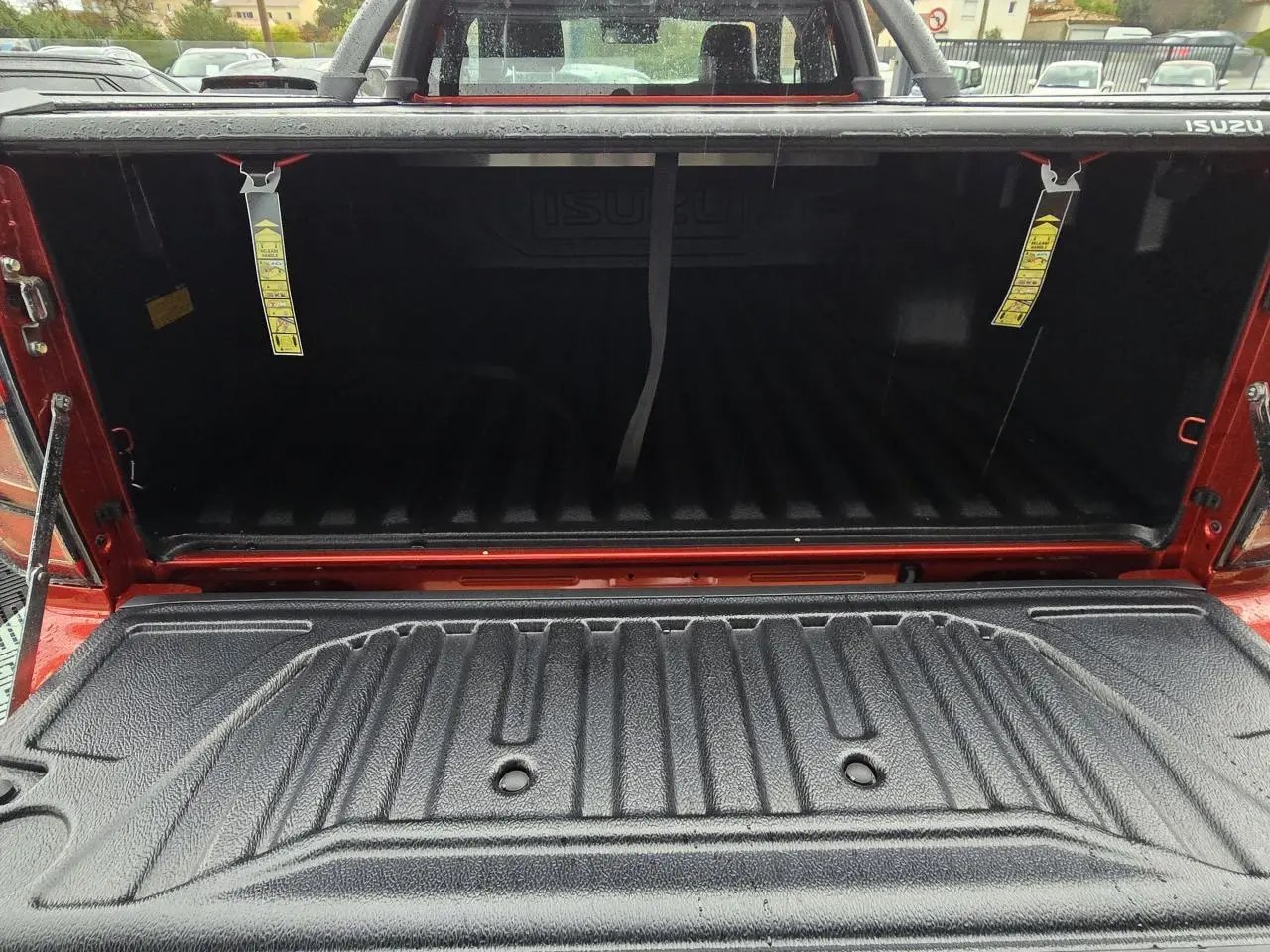 Vue arrière du bac de benne noir avec rideau Shutter Lid sur pick-up Isuzu D-MAX orange métallisé.