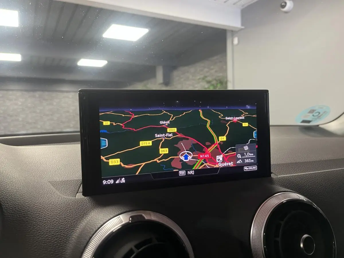Écran central du système de navigation Audi Q2 2024 affichant une carte routière colorée en intérieur du véhicule.