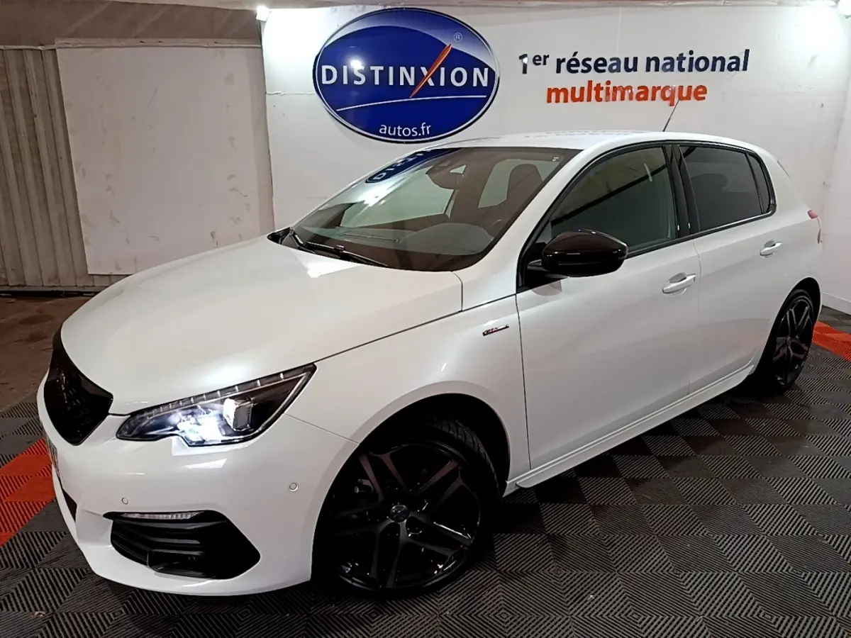 PEUGEOT 308 Puretech GT Line blanc vue 3/4 avant droit avec phares LED allumés et jantes noires sportives