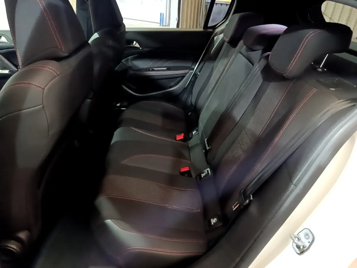 Vue intérieure côté droit des sièges arrière noirs avec surpiqûres rouges d'une Peugeot 308 GT Line blanche de 2019