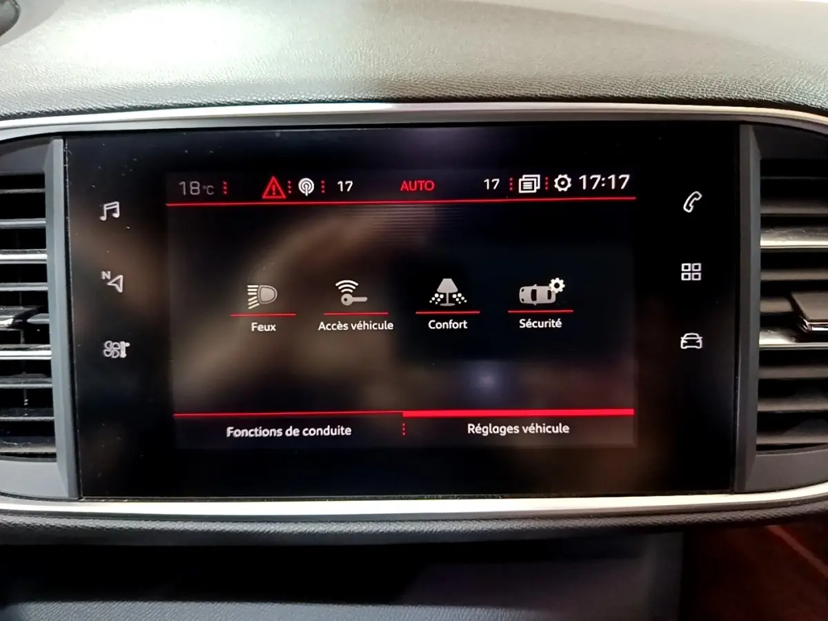 Écran tactile central du tableau de bord de la Peugeot 308 blanc, affichant les réglages de conduite et sécurité.