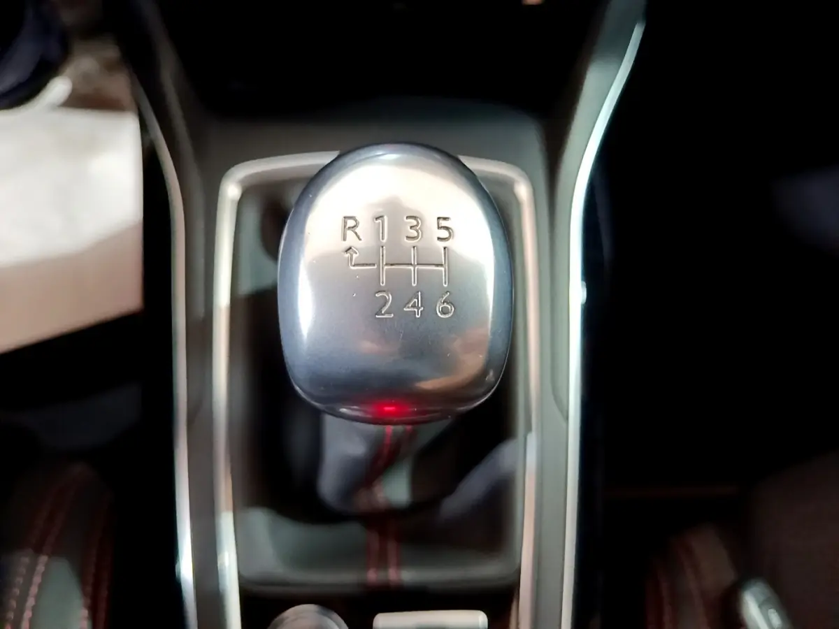 Le levier de vitesses manuel argenté de la Peugeot 308 GT Line blanc, vu en gros plan intérieur.