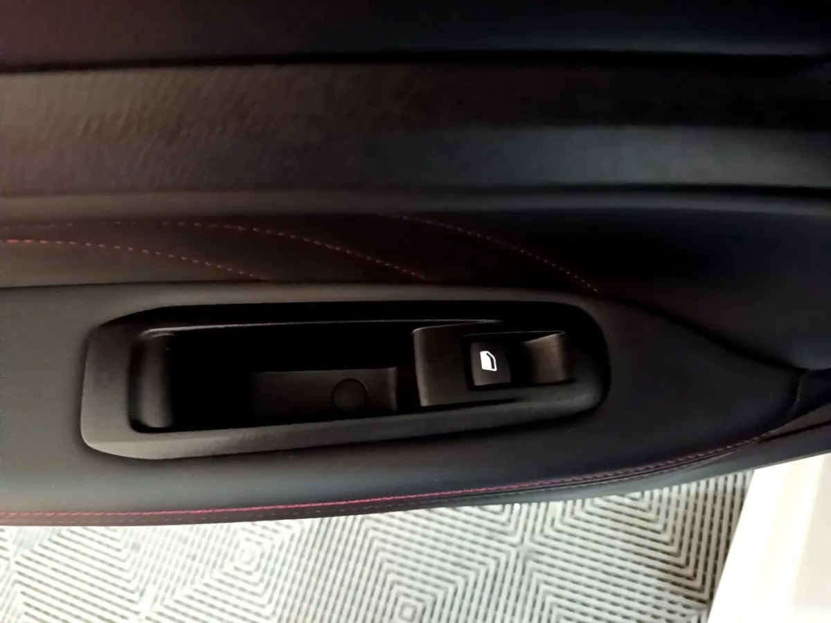 Gros plan sur la commande de lève-vitre côté gauche, garniture noire avec surpiqûres rouges, Peugeot 308 blanc 2019.