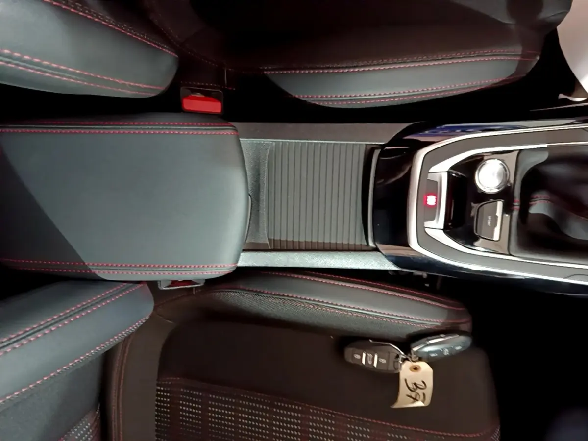 Vue plongeante sur la console centrale et sièges noirs avec surpiqûres rouges de la Peugeot 308 GT Line 2019
