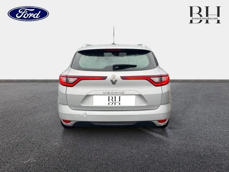 Vue arrière d'une Renault Mégane Break gris platine de 2020 avec feux arrière LED étirés et barres de toit visibles.