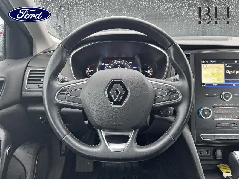 Vue intérieure centrée sur le volant cuir multifonction de la Renault Mégane Break gris platine avec tableau de bord et écran tactile.