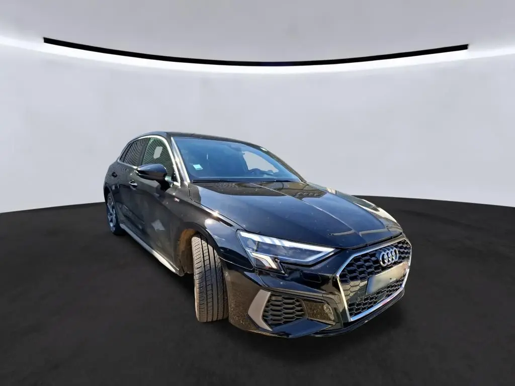 Audi A3 Sportback noir en 3/4 avant droit, avec calandre hexagonale et jantes alliage 18 pouces visibles.