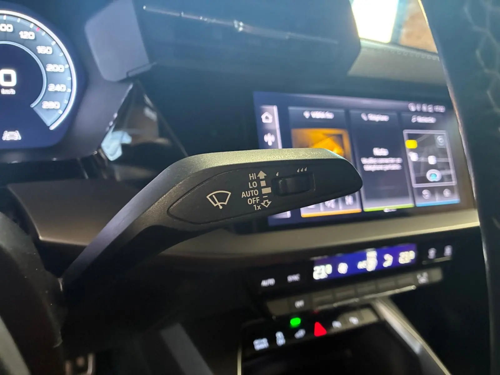 Gros plan sur la commande d’essuie-glace à gauche du volant dans l’habitacle noir de l’Audi A3 Sportback 2023.