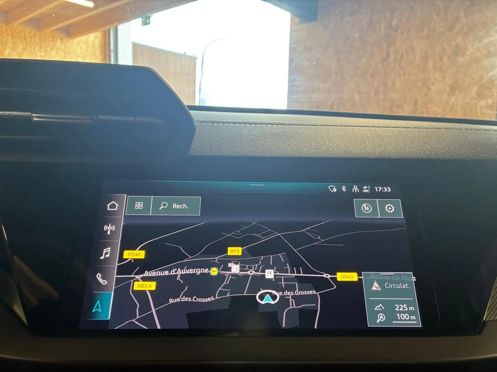 Écran tactile du système de navigation MMI plus dans l'habitacle de l'Audi A3 Sportback noir, vue frontale rapprochée.