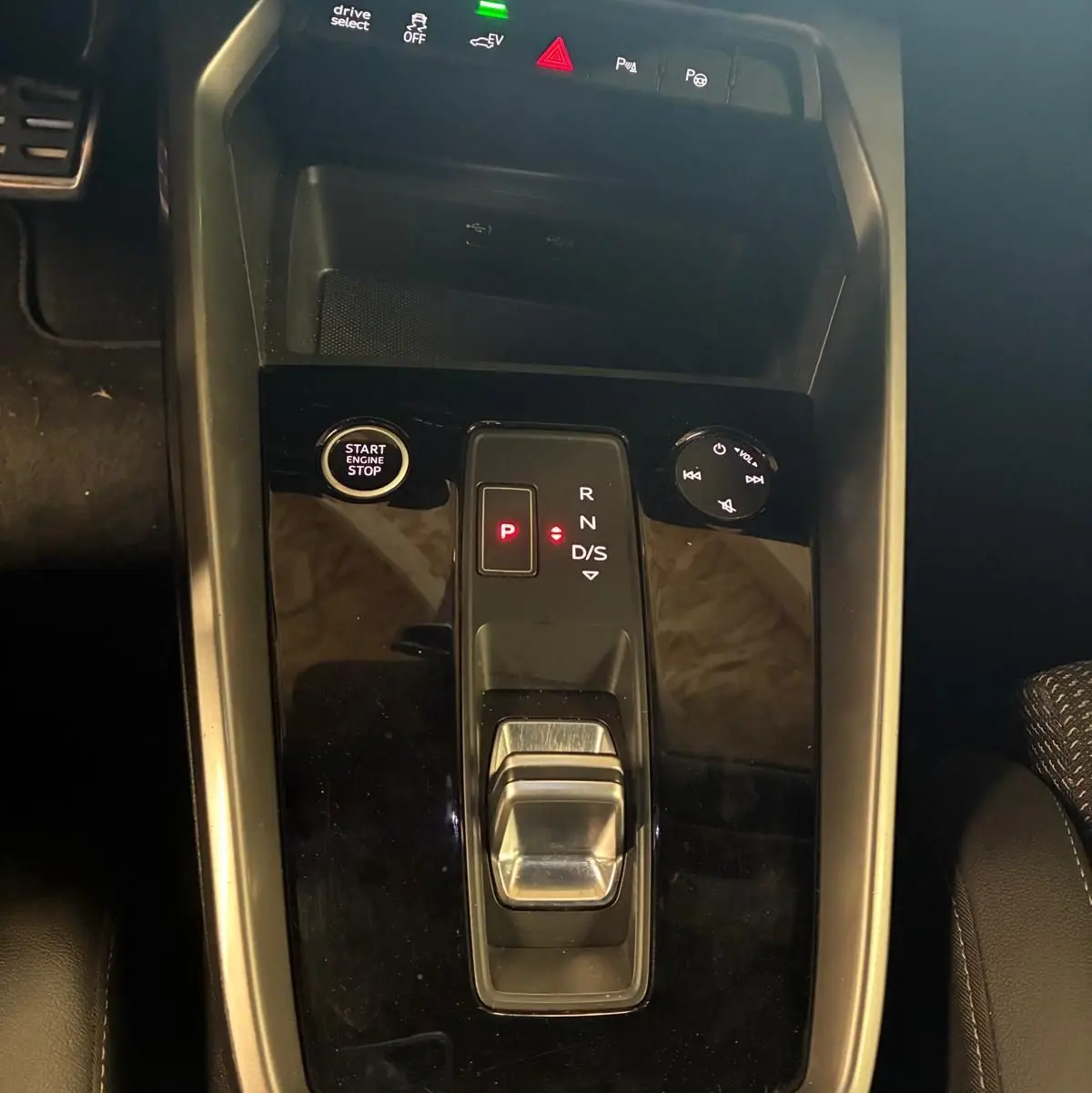 Vue plongeante sur la console centrale noire de l’Audi A3 Sportback 2023, avec levier de vitesse automatique et bouton start/stop.